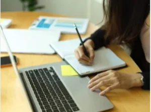 student researching scholarships laptop notes planning month one 2026