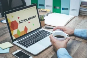 student writing cover letter scholarship application laptop desk 2026
